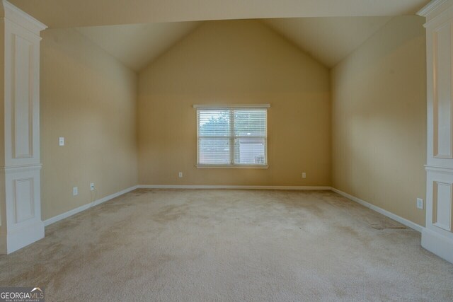 1186 Diamond Xing, Mcdonough, GA 30252 - empty room with carpet flooring, vaulted ceiling, and baseboards