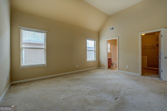 1186 Diamond Xing, Mcdonough, GA 30252 - unfurnished bedroom featuring multiple windows, carpet, lofted ceiling, a spacious closet, and baseboards