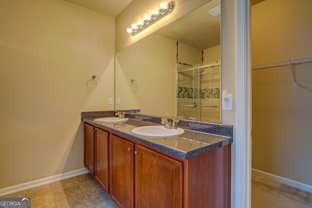 1186 Diamond Xing, Mcdonough, GA 30252 - bathroom featuring a shower stall, double vanity, baseboards, and a walk in closet