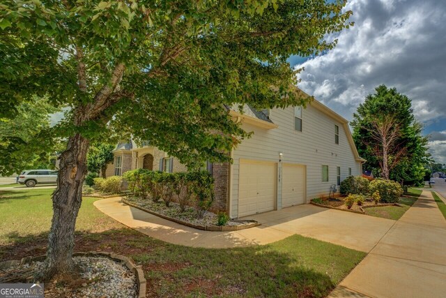 1186 Diamond Xing, Mcdonough, GA 30252 - view of side of property with a garage, a lawn, concrete driveway, and brick siding