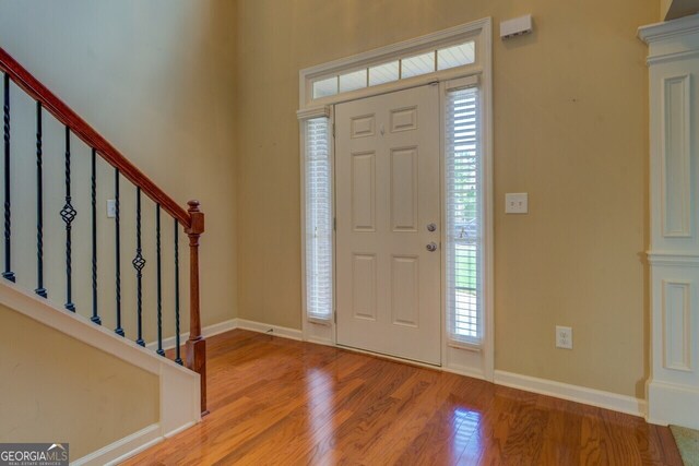 1186 Diamond Xing, Mcdonough, GA 30252 - entrance foyer with healthy amount of natural light, wood finished floors, stairs, and baseboards