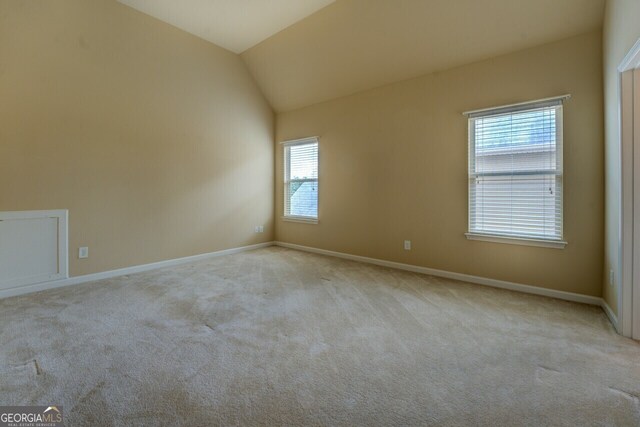 1186 Diamond Xing, Mcdonough, GA 30252 - carpeted spare room with baseboards and lofted ceiling