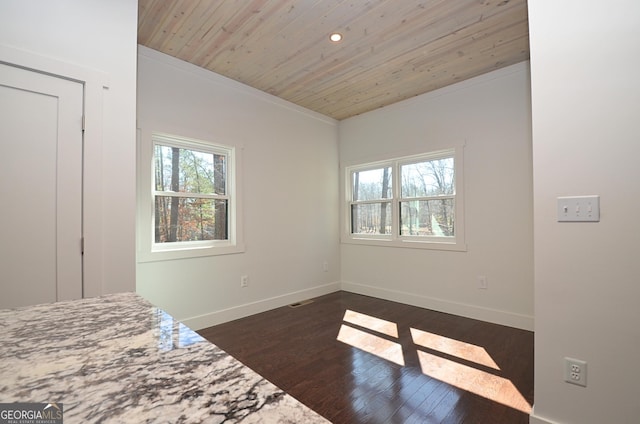 unfurnished bedroom featuring wood ceiling, dark wood-style flooring, crown molding, and baseboards