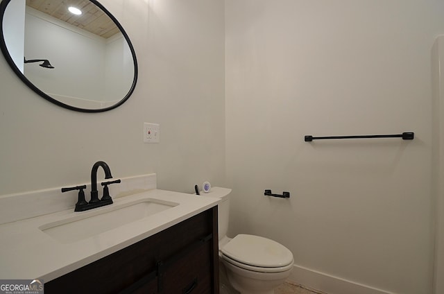 bathroom featuring toilet, vanity, and baseboards