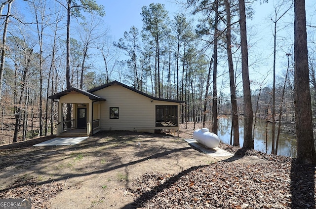 view of side of home with a sunroom and a water view