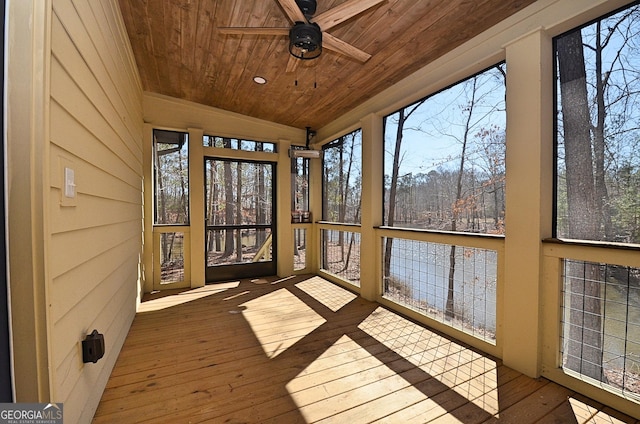 unfurnished sunroom featuring a ceiling fan, plenty of natural light, wood ceiling, and vaulted ceiling