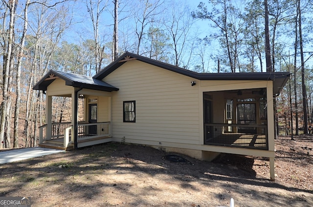 view of home's exterior featuring a porch, metal roof, and a ceiling fan