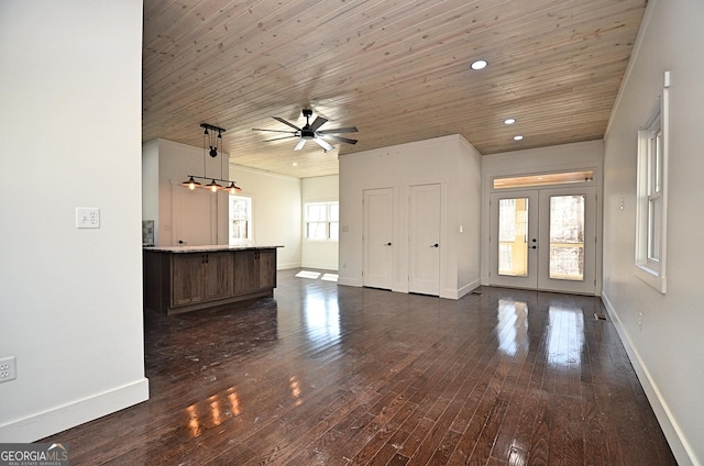 unfurnished living room featuring french doors, dark wood-type flooring, wooden ceiling, and baseboards