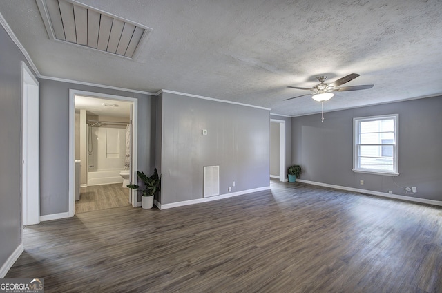 empty room featuring ornamental molding, visible vents, a textured ceiling, and dark wood-style floors