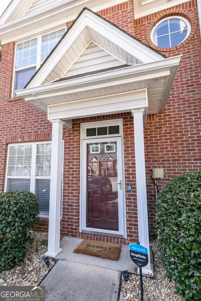 view of exterior entry with brick siding