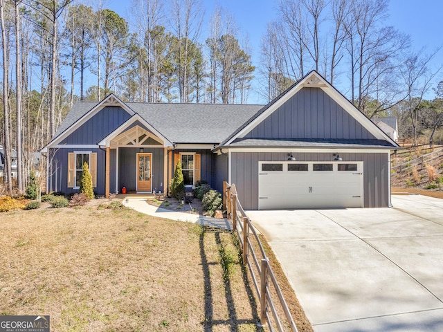 view of front of property featuring driveway, board and batten siding, an attached garage, and roof with shingles