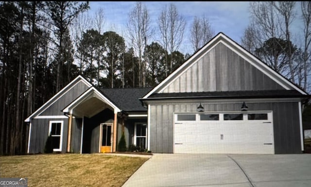 view of front of house featuring board and batten siding, a front lawn, driveway, and an attached garage