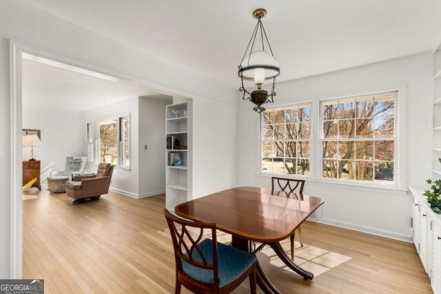 dining space featuring light wood-style floors and baseboards