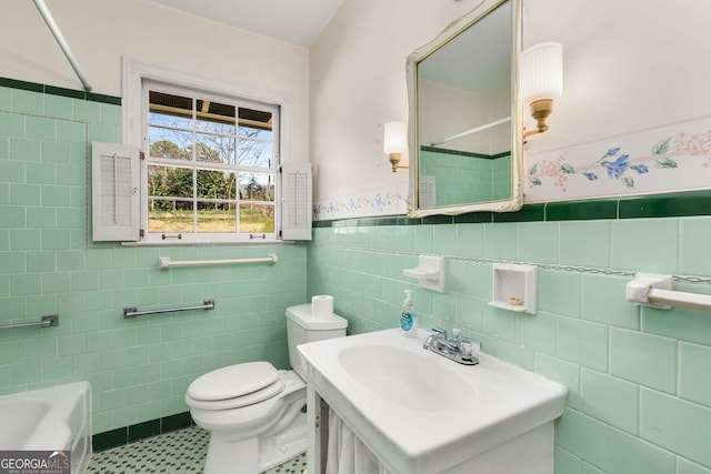 full bathroom featuring a tub to relax in, toilet, vanity, a shower, and wainscoting