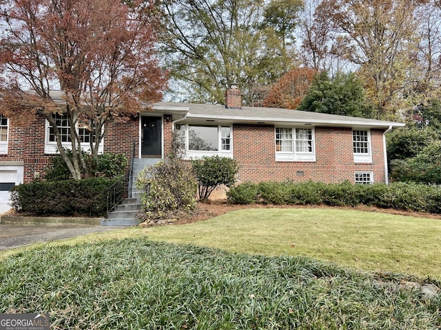 single story home with brick siding, a chimney, and a front yard