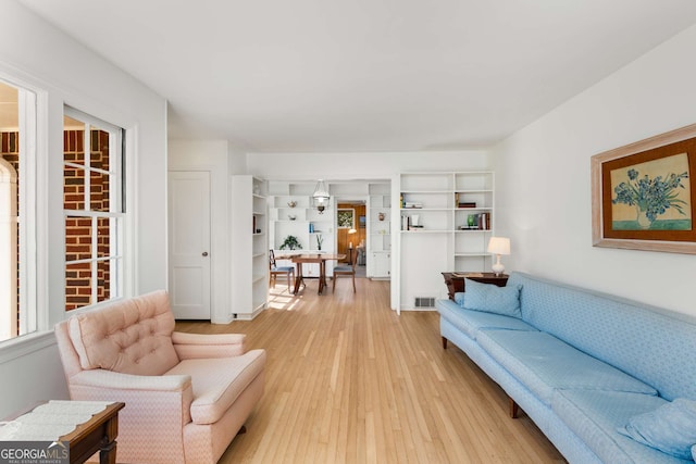 living room featuring light wood finished floors and visible vents