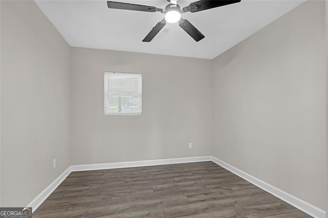 empty room featuring dark wood-type flooring, baseboards, and a ceiling fan