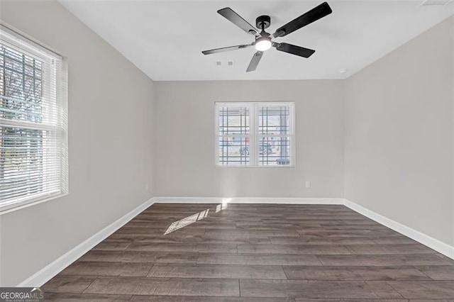 empty room featuring ceiling fan, wood finished floors, visible vents, and baseboards