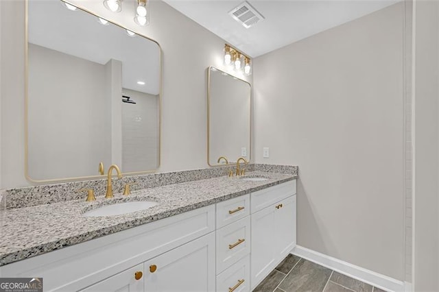 full bathroom with visible vents, a sink, baseboards, and double vanity