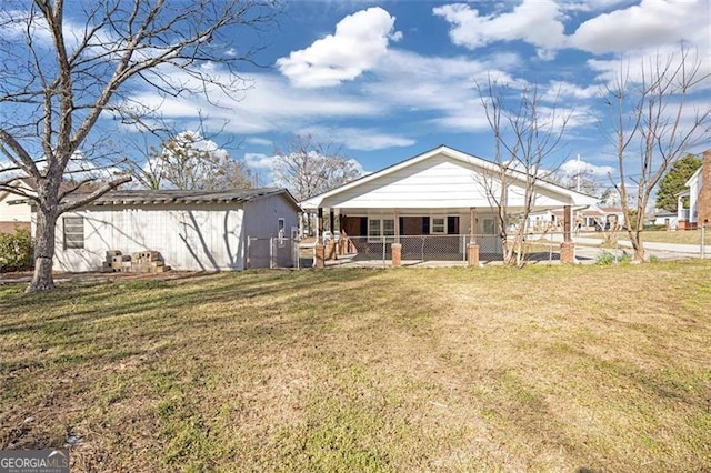 rear view of house featuring fence and a yard