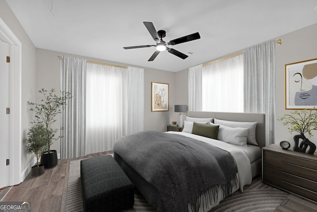 bedroom featuring ceiling fan, wood finished floors, and visible vents