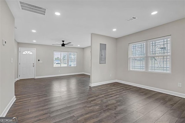 unfurnished living room featuring dark wood-type flooring, recessed lighting, visible vents, and electric panel