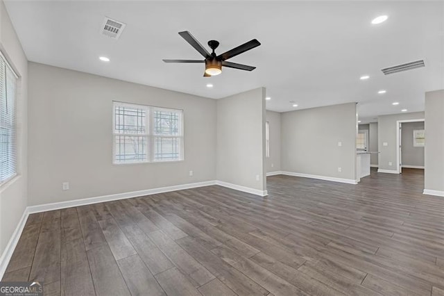 unfurnished living room with recessed lighting, visible vents, dark wood finished floors, and baseboards