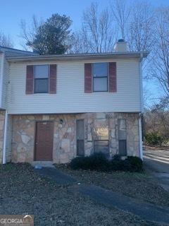 view of front of property with stone siding and a chimney