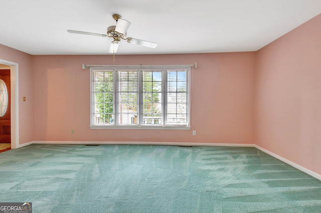 spare room featuring carpet, baseboards, and a ceiling fan