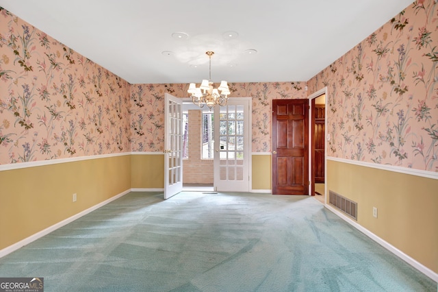 unfurnished dining area featuring wallpapered walls, baseboards, visible vents, an inviting chandelier, and carpet floors