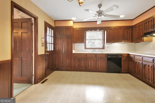 kitchen featuring wainscoting, light countertops, dishwasher, and a sink