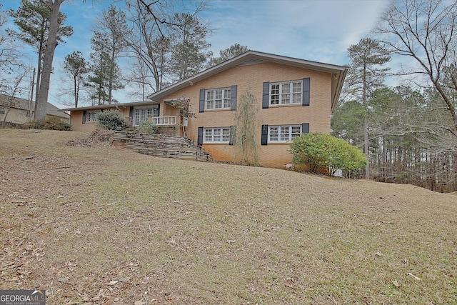 back of property featuring brick siding and a lawn