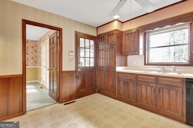 kitchen featuring a wainscoted wall, light colored carpet, light countertops, visible vents, and dishwasher