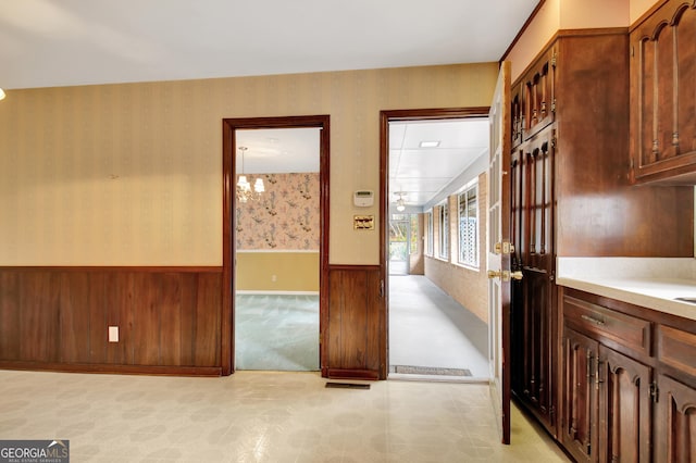 interior space featuring a wainscoted wall and wallpapered walls