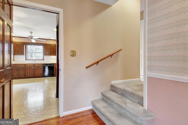 staircase with ceiling fan, baseboards, and wood finished floors