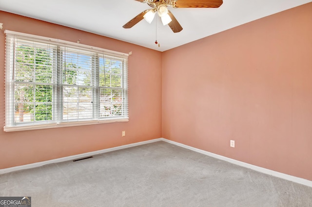 carpeted empty room with visible vents, baseboards, and ceiling fan