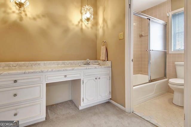 bathroom featuring toilet, tile patterned floors, bath / shower combo with glass door, and vanity