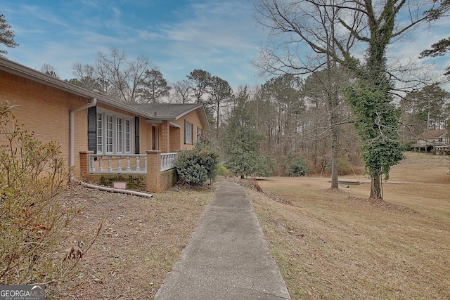 view of property exterior with a yard and brick siding