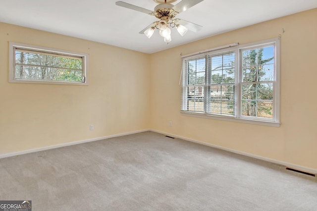 unfurnished room with baseboards, visible vents, and light colored carpet