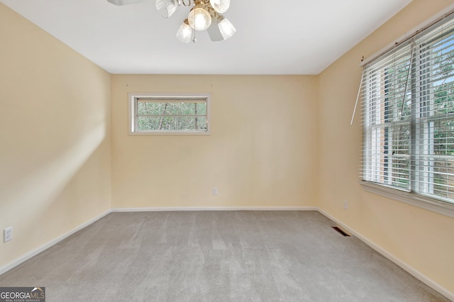 empty room with ceiling fan, baseboards, and light colored carpet