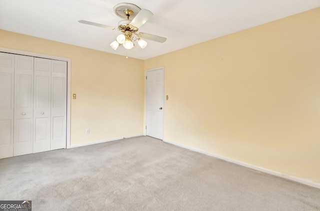 unfurnished bedroom with a ceiling fan, a closet, light carpet, and baseboards