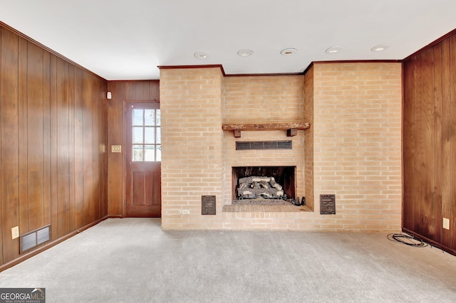 unfurnished living room with a fireplace, visible vents, and light colored carpet