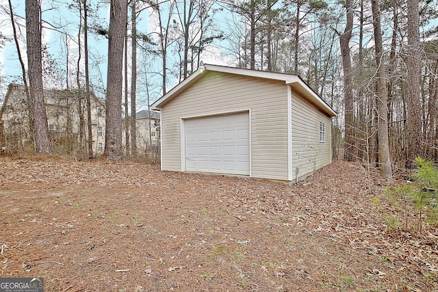 detached garage featuring dirt driveway