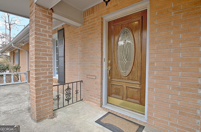 doorway to property with brick siding