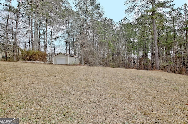 view of yard featuring a garage and an outdoor structure