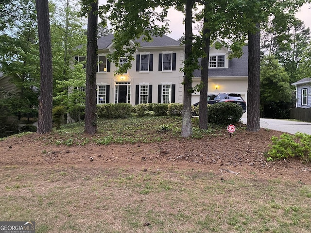 colonial inspired home featuring concrete driveway