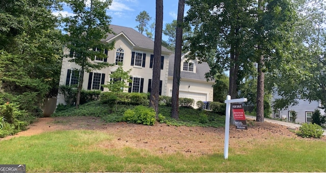 colonial house featuring a front lawn and stucco siding