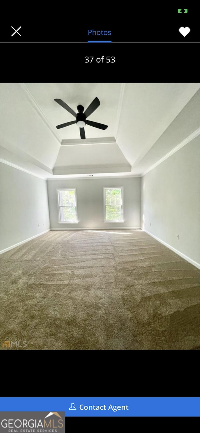 spare room featuring carpet floors, a tray ceiling, a ceiling fan, and baseboards