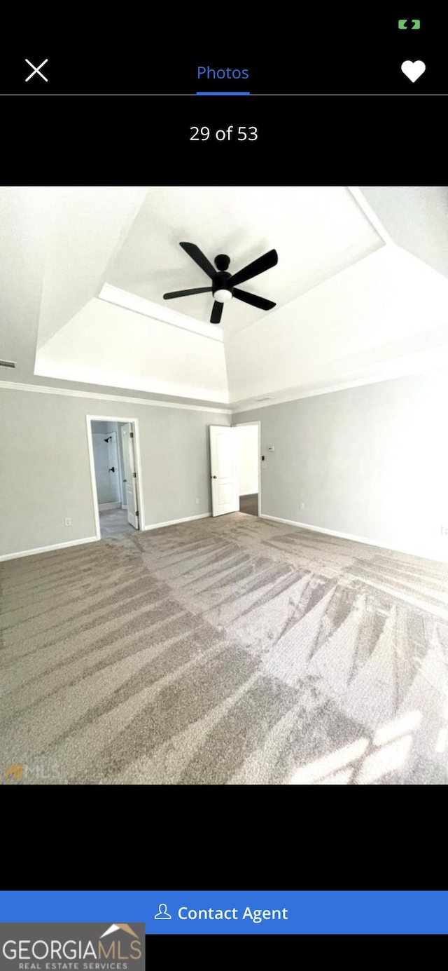 interior space featuring ceiling fan, a tray ceiling, visible vents, and baseboards