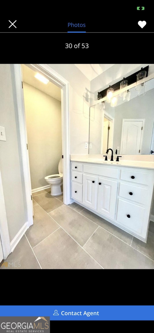 bathroom with toilet, tile patterned flooring, vanity, and baseboards